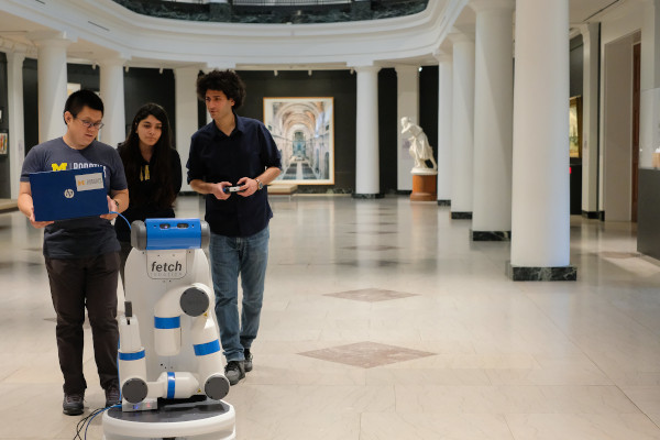 Arts and Robotics students collaborating around a robot in the U-M Museum