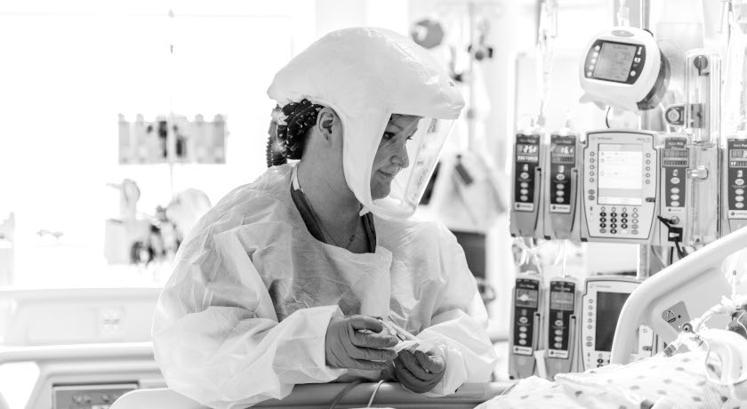 Black and white image of a nurse treating a patient in the new COVID-19 unit