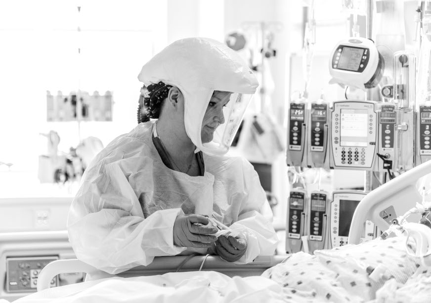 Black and white image of a nurse treating a patient in the new COVID-19 unit