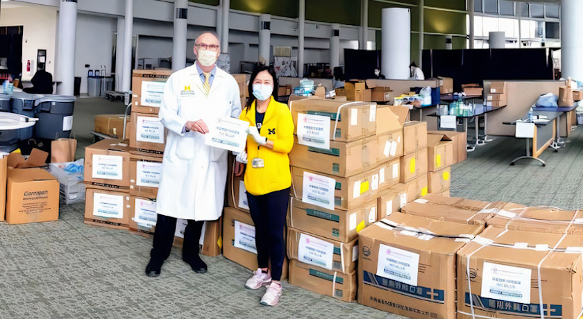 Michigan Medicine staff stand in front of multiple boxes of donated Personal Protective Equipment